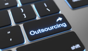 Tastaturtaste mit dem Wort „Outsourcing“ als Symbol für ausgelagerte Buchhaltungsdienstleistungen